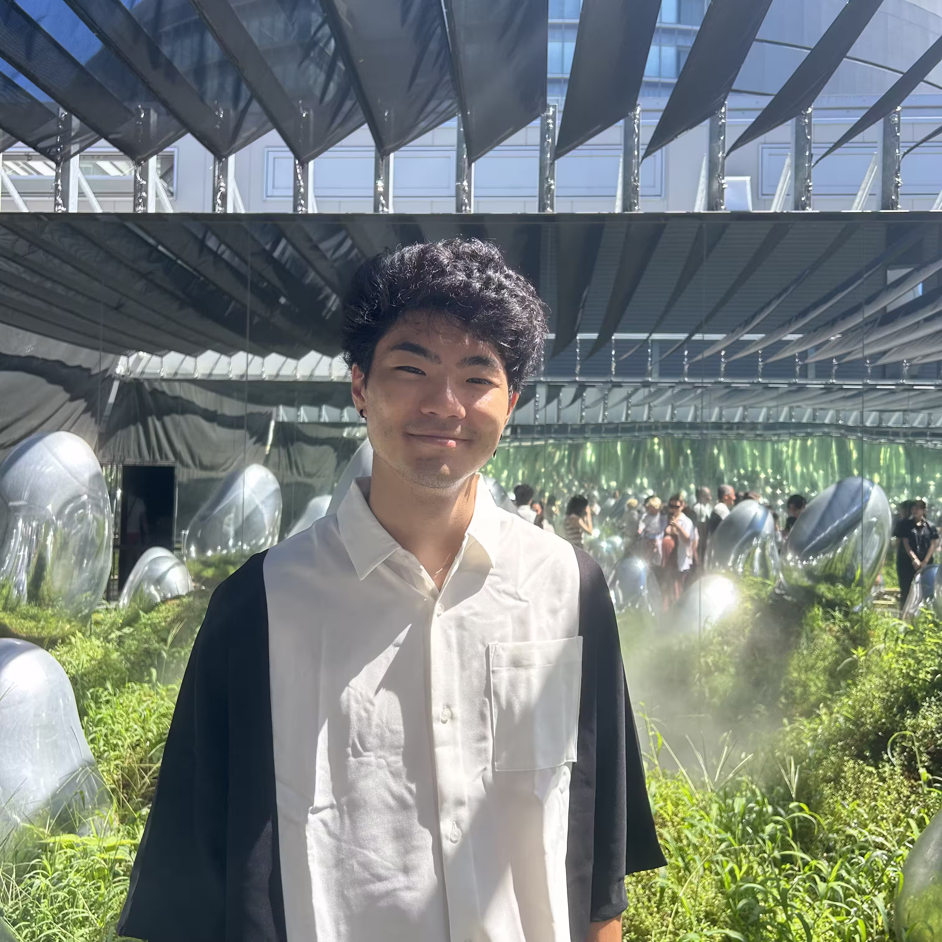 Rikuo Wada standing in a art backdrop